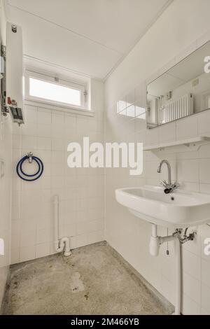 Intérieur des toilettes étroites avec lavabo et toilettes à chasse d'eau Banque D'Images