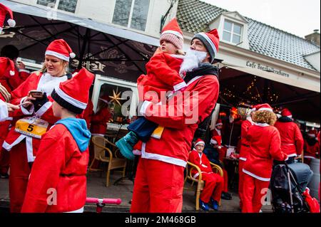 18 décembre, Breda. De nombreuses villes du monde entier accueillent de nos jours les événements du Santa Run. Dans la ville néerlandaise de Breda, deux cents personnes, dont des parents avec leurs enfants, ont couru en costumes du Père Noël à environ 3 km pendant la course du Père Noël. L'événement annuel était organisé par la fondation 'Rotary Santa Run'. L'événement a permis de recueillir au moins 8,000 € pour deux associations caritatives locales, la « Youth Breakfast Breda Foundation » et la fondation « Het Bonte Perdje », qui vise à offrir aux jeunes handicapés la possibilité de pratiquer des sports équestres en toute sécurité. Banque D'Images