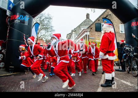 18 décembre, Breda. De nombreuses villes du monde entier accueillent de nos jours les événements du Santa Run. Dans la ville néerlandaise de Breda, deux cents personnes, dont des parents avec leurs enfants, ont couru en costumes du Père Noël à environ 3 km pendant la course du Père Noël. L'événement annuel était organisé par la fondation 'Rotary Santa Run'. L'événement a permis de recueillir au moins 8,000 € pour deux associations caritatives locales, la « Youth Breakfast Breda Foundation » et la fondation « Het Bonte Perdje », qui vise à offrir aux jeunes handicapés la possibilité de pratiquer des sports équestres en toute sécurité. Banque D'Images