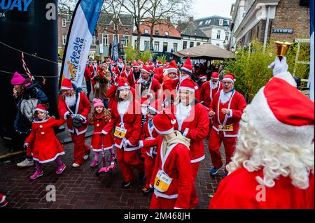 18 décembre, Breda. De nombreuses villes du monde entier accueillent de nos jours les événements du Santa Run. Dans la ville néerlandaise de Breda, deux cents personnes, dont des parents avec leurs enfants, ont couru en costumes du Père Noël à environ 3 km pendant la course du Père Noël. L'événement annuel était organisé par la fondation 'Rotary Santa Run'. L'événement a permis de recueillir au moins 8,000 € pour deux associations caritatives locales, la « Youth Breakfast Breda Foundation » et la fondation « Het Bonte Perdje », qui vise à offrir aux jeunes handicapés la possibilité de pratiquer des sports équestres en toute sécurité. Banque D'Images