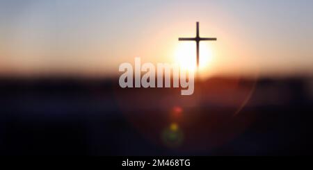 Un arrière-plan éclatant au lever du soleil de la nouvelle année avec un bokeh lumineux et une silhouette sainte de la croix de Jésus-Christ Banque D'Images