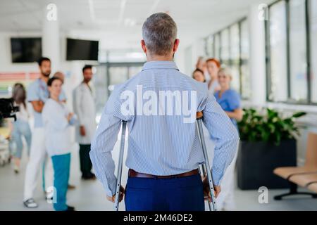 Le personnel médical se claque sur un patient qui s'est remis d'un accident grave. Banque D'Images