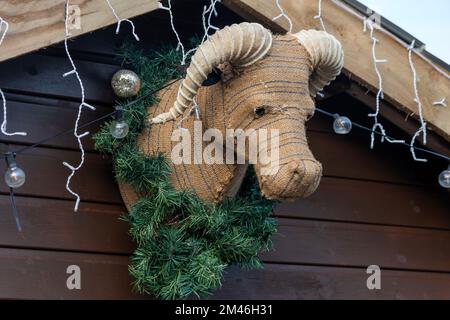 Décoration de Noël bourrée de vache bovine suspendue sur un mur en bois pendant la saison festive célébrant la nativité de Jésus Christ, stoc Banque D'Images