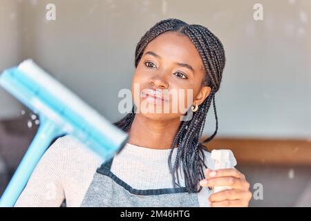 Nettoyage, fenêtre et femme noire avec de l'eau pour les corvées, les travaux ménagers et le nettoyage de printemps d'une maison. Lavage, pulvérisation et nettoyant africain avec des produits pour Banque D'Images