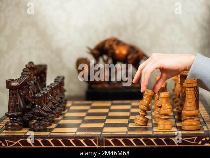 lady fait le premier mouvement avec un pion en bois blanc dans le jeu d'échecs à l'intérieur vintage de salon Banque D'Images