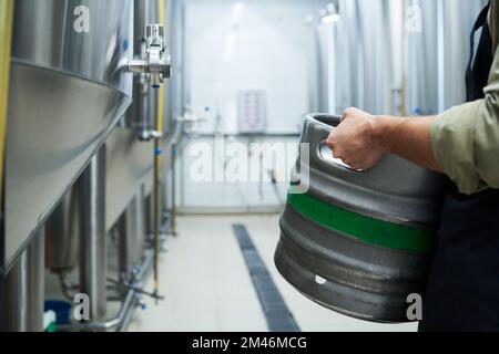 Image rognée d'un fabricant mâle transportant un fût avec de la bière fraîche Banque D'Images