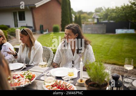 Amis qui ont repas dans le jardin Banque D'Images