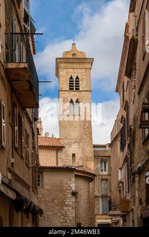 Bonifacio, France - 2 décembre 2022 : rue étroite du centre-ville historique de Bonifacio avec l'église clocher de l'église Sainte Marie majeure Banque D'Images