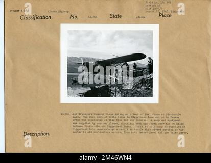 Avion de commandement du transport aérien au lac Pickhandle. Légende originale : avion de commandement du transport aérien prenant une charge de fûts de carburant au lac Pickhandle. La route à l'ouest de la rivière White jusqu'au lac Niggerhead et jusqu'au ruisseau Beaver était impasible à l'heure actuelle pour tout véhicule. Un camp et de l'équipement ont été fournis par des pontons, faisant des allers-retours sur les 30 milles entre Pickhandle et Niggerhead Lakes. Les travaux de ce camp ainsi fournis au lac Niggerhead ont pu, par conséquent, s'attaquer à cette section fermée du centre pour aider les entrepreneurs travaillant à la fois à Beaver Creek et à la rivière White. Photo de Pinkst Banque D'Images
