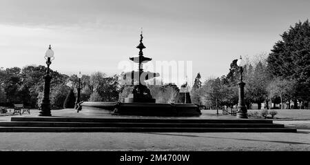 Une photo en niveaux de gris du parc avec une grande fontaine Banque D'Images