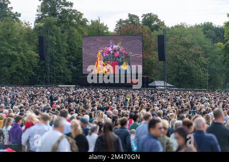 Une grande foule se mêle à Hyde Park en regardant la diffusion en direct des funérailles sa Majesté la reine Elizabeth II qui se déroule à l'abbaye de Westminster, sur gi Banque D'Images