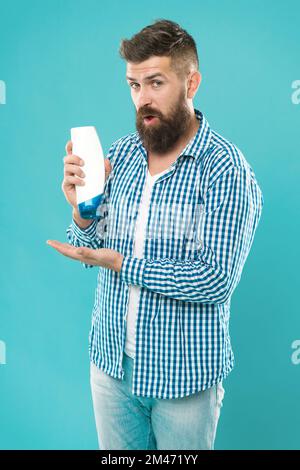 surpris par le résultat. beauté masculine. auto-hygiène. Bonjour. choisissez cette mousse. bouteille de shampooing pour hipster brutal. Homme barbu avec des cheveux sains Banque D'Images