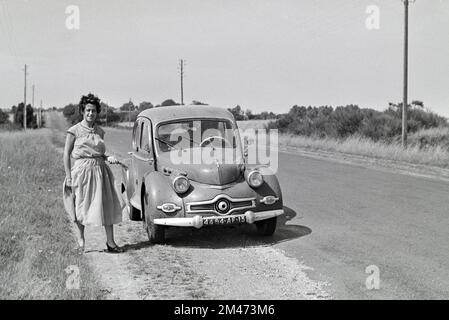 Jeune française 1950s femme pose devant un Panhard Vintage Dyna X produit entre 1948 et 1954. Voiture d'époque photographiée in1955 Banque D'Images