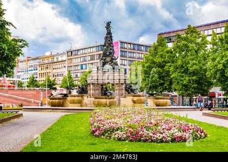 Vue pittoresque d'un lit à fleurs rempli de pansies de jardin blanc et rose sur la place Paradeplatz avec la célèbre sculpture Grupello Pyramid à l'arrière Banque D'Images