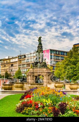 Vue pittoresque d'un lit de fleurs sur la place Paradeplatz avec la célèbre sculpture Grupello Pyramid en arrière-plan, par une journée nuageux dans la ville... Banque D'Images