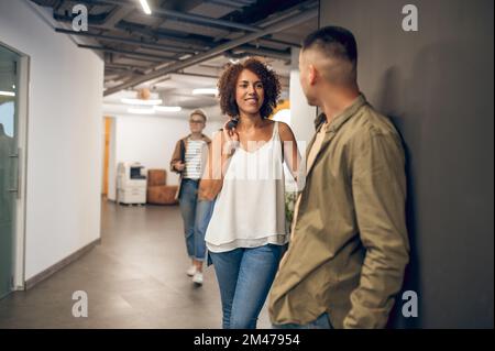 Employé de l'entreprise souriant à son collègue dans le couloir Banque D'Images