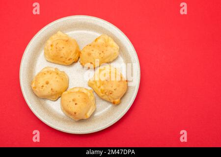 En-cas brésilien du pain au fromage pao de queijo sur un plat blanc Banque D'Images