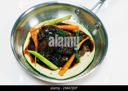 épaule d'agneau tirée lentement cuite avec légumes et purée de pommes de terre Banque D'Images