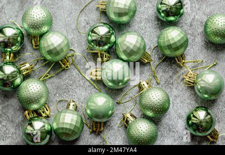 Couleur verte et dorée décoration d'arbre de Noël boules sur fond de pierre. Vue de dessus Banque D'Images