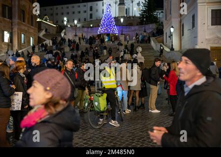 Rome, Italie - 26 novembre 2022: Cycliste prend un selfie avec son téléphone mobile dans les marches espagnoles bondées décorées de lumières de Noël. Banque D'Images