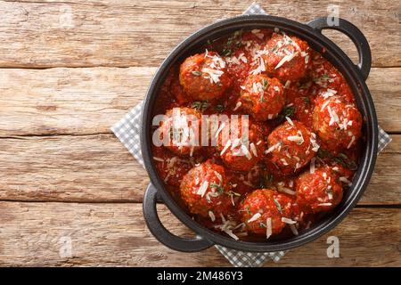 Boulettes de viande de polypette au parmesan compotée dans une riche sauce tomate en gros plan dans une poêle à frire sur la table. Vue horizontale du dessus Banque D'Images