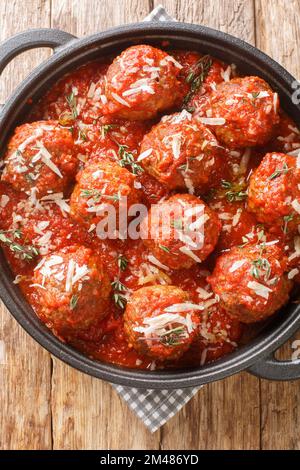 Polpette al Sugo boulettes de viande italiennes juteuses dans une riche sauce tomate, à proximité de la poêle sur la table en bois. Vue verticale du dessus Banque D'Images