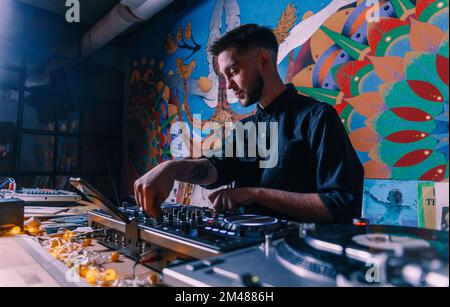 Un DJ joue un ensemble de musique dans un club. Banque D'Images