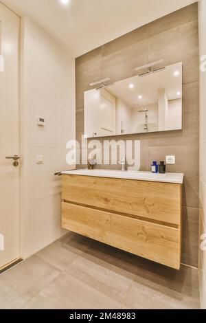 une salle de bains avec un lavabo et un miroir dans le coin, prise de dessus, c'est une image d'une porte blanche sur le mur Banque D'Images