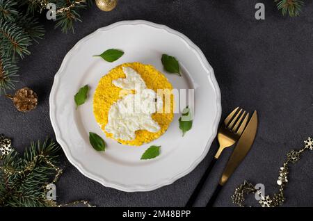 Salade feuilletée Mimosa pour le nouvel an 2023 avec thon en conserve, pommes de terre et carottes, lapin décoré d'œufs Banque D'Images