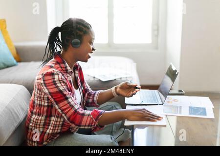 Jeune étudiante africaine assistant à un séminaire en ligne ou à une formation en ligne Banque D'Images