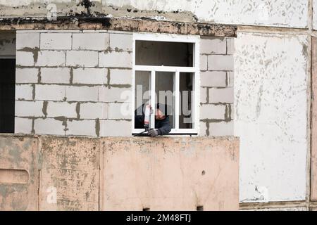 Tiraspol, Moldavie - 6 décembre 2022: Installation de nouvelles fenêtres en plastique sur un vieux balcon. Ouvrier monter une nouvelle fenêtre à faible consommation d'énergie dans le balcon avec Banque D'Images