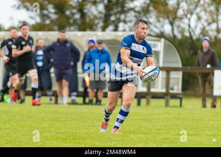 Le joueur de Howe of Fife court avec le ballon de rugby dans les deux mains pendant le match de rugby de Berwick contre le match de rugby de Howe of Fife pour hommes Banque D'Images