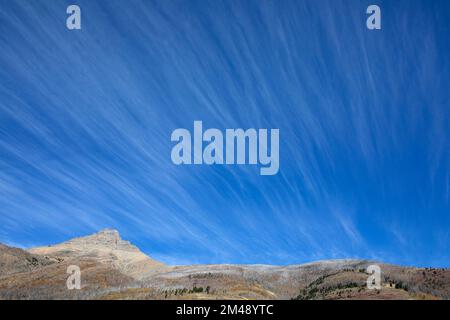 Nuages de cirrus dans un ciel bleu vif au-dessus des montagnes Rocheuses dans le parc national des Lacs-Wateron, Alberta, Canada Banque D'Images
