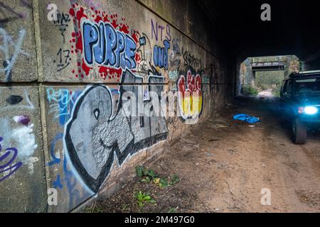 Graffiti mural et pourboire à l'intérieur d'un tunnel routier abandonné. Banque D'Images