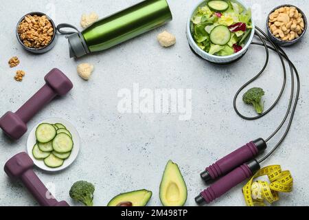 Cadre fait de nourriture saine, haltères, corde à sauter et bouteille sur fond de grunge Banque D'Images