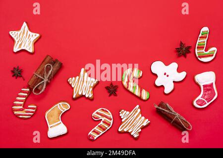 Composition avec délicieux biscuits de Noël et épices sur fond rouge Banque D'Images