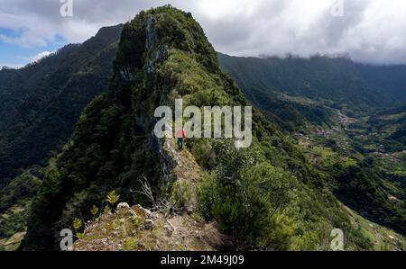 Randonneurs sur la crête de Pico do Alto, vue sur les montagnes densément cultivées et le village de Boaventura, Madère, Portugal Banque D'Images