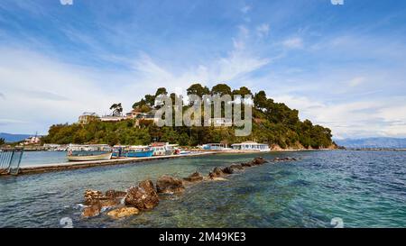 Prise de vue en grand angle, colline continentale, colline Kanoni, arbres, ciel bleu, Nuages blancs de plumes, rochers dans la mer, jetée, bateaux, Vlacherna, île de Corfou Banque D'Images