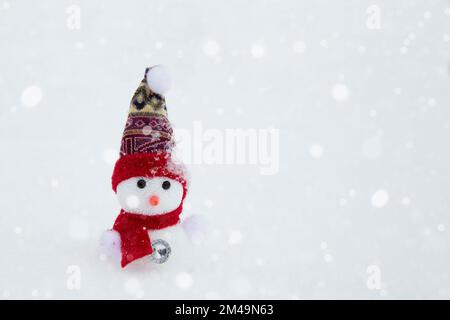 Un bonhomme de neige heureux se dresse sur un paysage hivernal. Fond de neige. Vide pour une conception avec un espace de copie. Conte de fées d'hiver. Banque D'Images