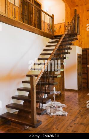 Escalier à poutres en bois menant à l'étage dans le couloir à l'intérieur de la maison en bois rond. Banque D'Images