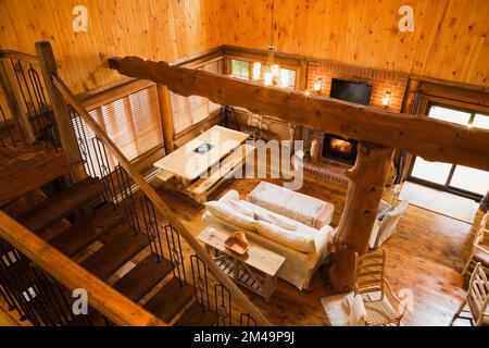 Vue sur la salle à manger au rez-de-chaussée, salle de séjour à partir de l'étage à l'intérieur de la maison en rondins. Banque D'Images
