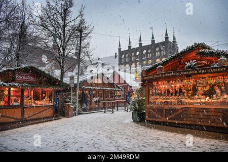 Lübeck, Allemagne, 15 décembre 2022: Marché de Noël dans la neige avec des stands romantiques et l'hôtel de ville historique de Lübeck en arrière-plan, Copy spa Banque D'Images