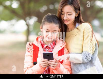 Bonne mère et bonne fille regardant le smartphone Banque D'Images