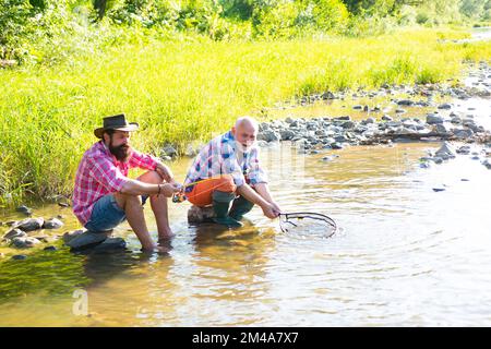 Pêcheurs hommes amis et truite trophée. Père et fils de pêche. Générations hommes pêche dans la rivière. Banque D'Images