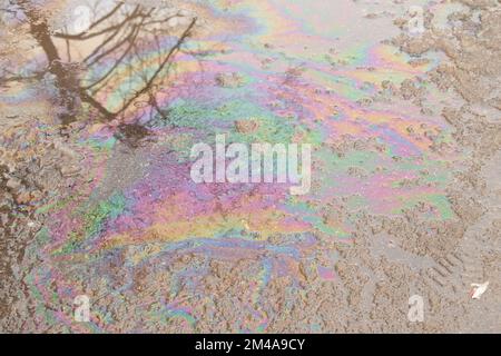 de l'essence s'est répandue sur la route dans une flaque d'eau colorée Banque D'Images