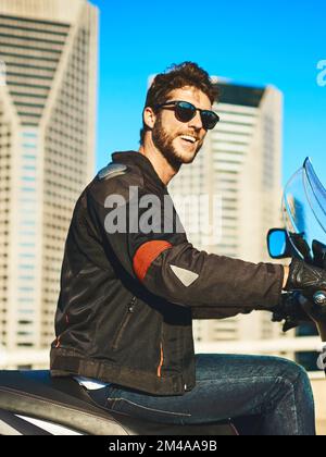 Je ressens une plus grande connexion avec mon environnement sur mon vélo. un jeune homme qui fait une moto à travers la ville. Banque D'Images