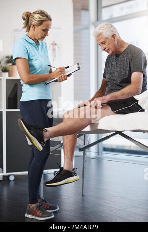 La douleur est ici. Prise de vue en longueur d'une kinésithérapeute femelle mature travaillant avec une patiente mâle senior dans son bureau. Banque D'Images
