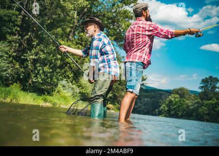 Pêcheurs hommes amis et truite trophée. Père et fils de pêche. Générations hommes pêche dans la rivière. Banque D'Images