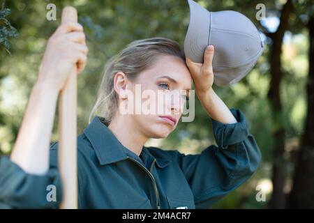 femme fatiguée femme jardinier tenant le râteau Banque D'Images