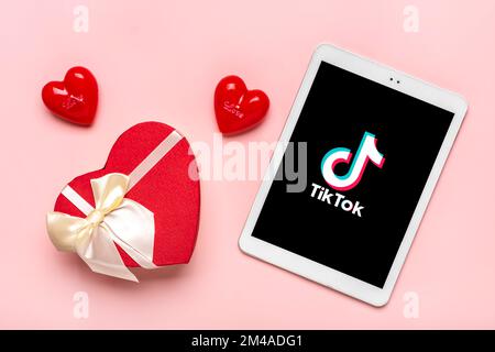 Bangkok, Thaïlande décembre 2022 smartphone Tik Tok icône de l'application, logo à l'écran, comme, deux coeurs rouges sur fond rose tendance des médias sociaux netwo Banque D'Images